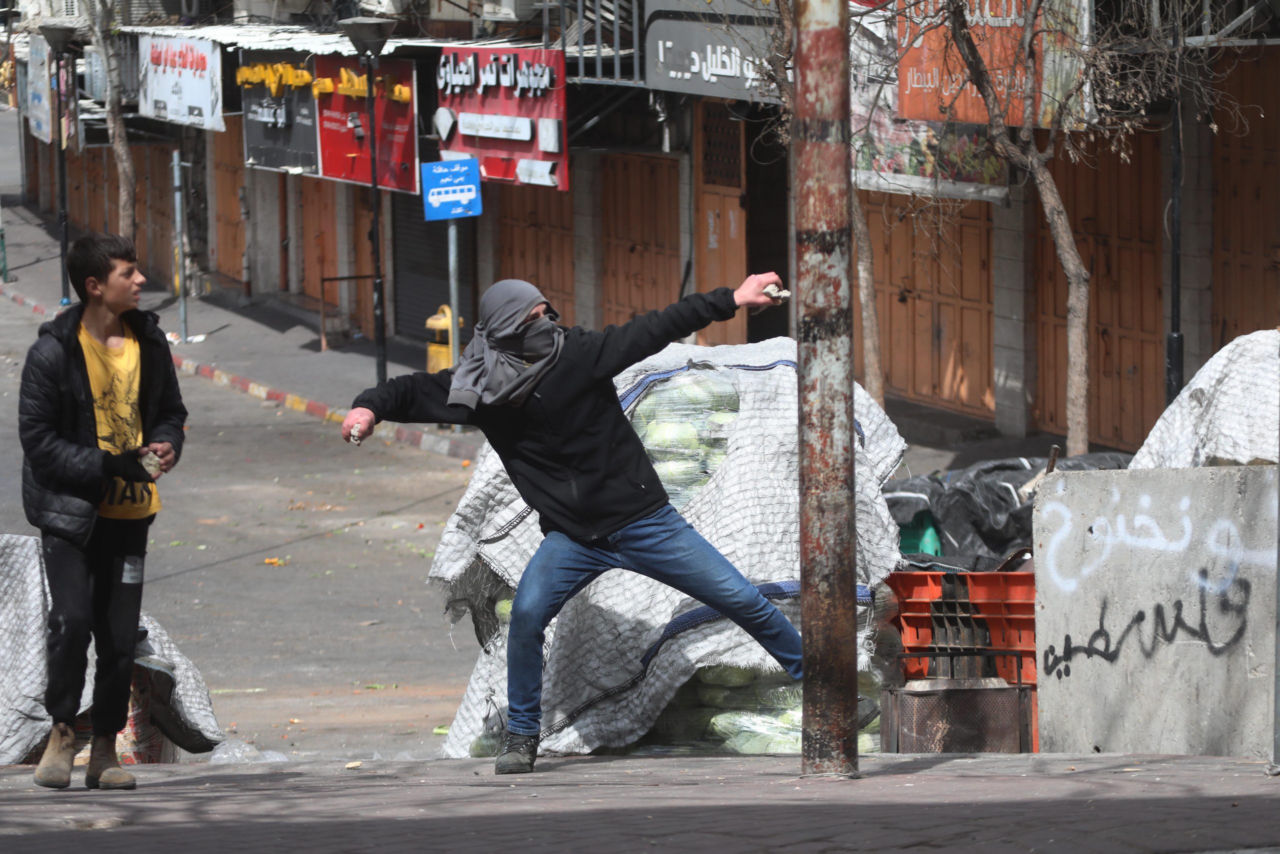 Israelske styrker forsøger at bremse protester i den palæstinensiske by Hebron, og palæstinensere svarer igen ved at kaste sten mod soldaterne.